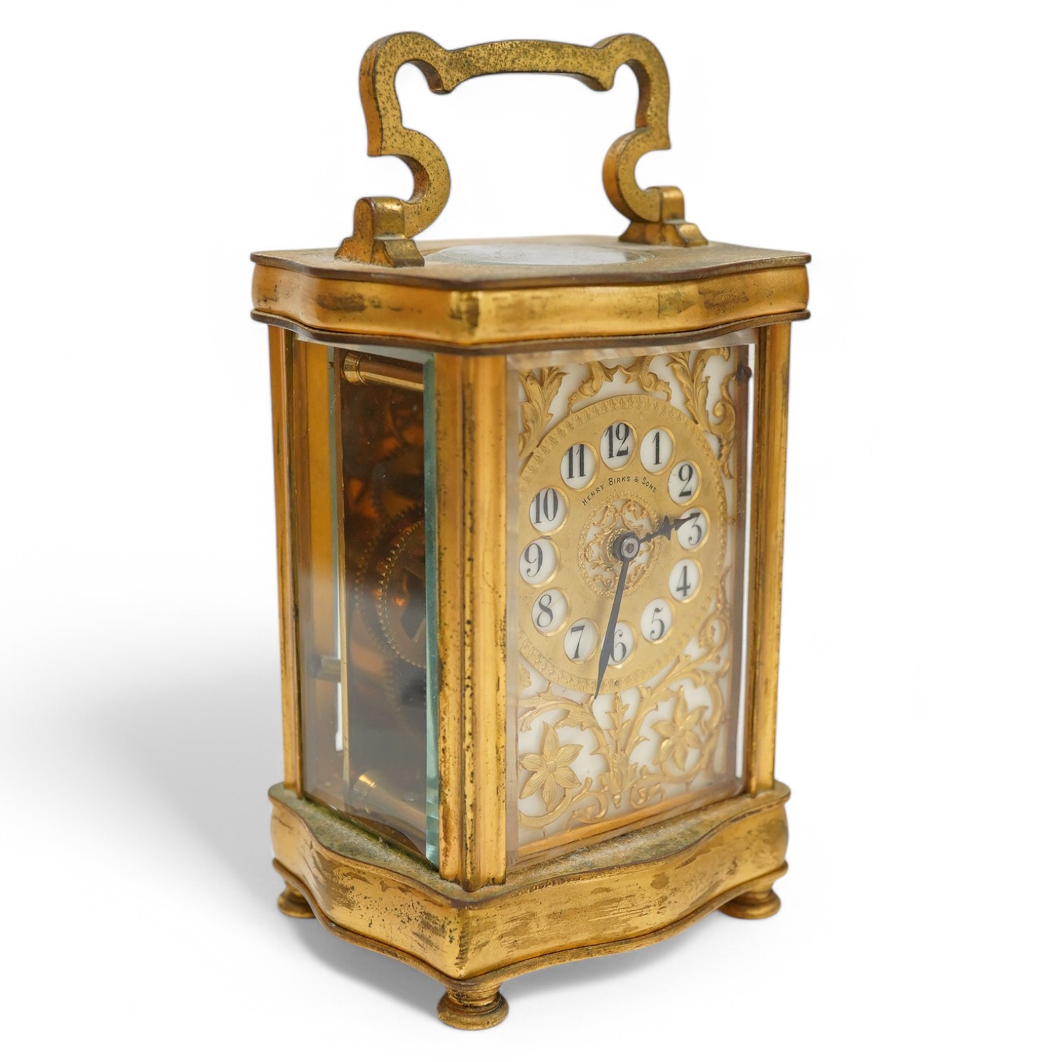 A late 19th / early 20th century ornate French gilt metal cased carriage timepiece, the dial inscribed Henry Birks, with key, 15cm high. Condition - fair, untested